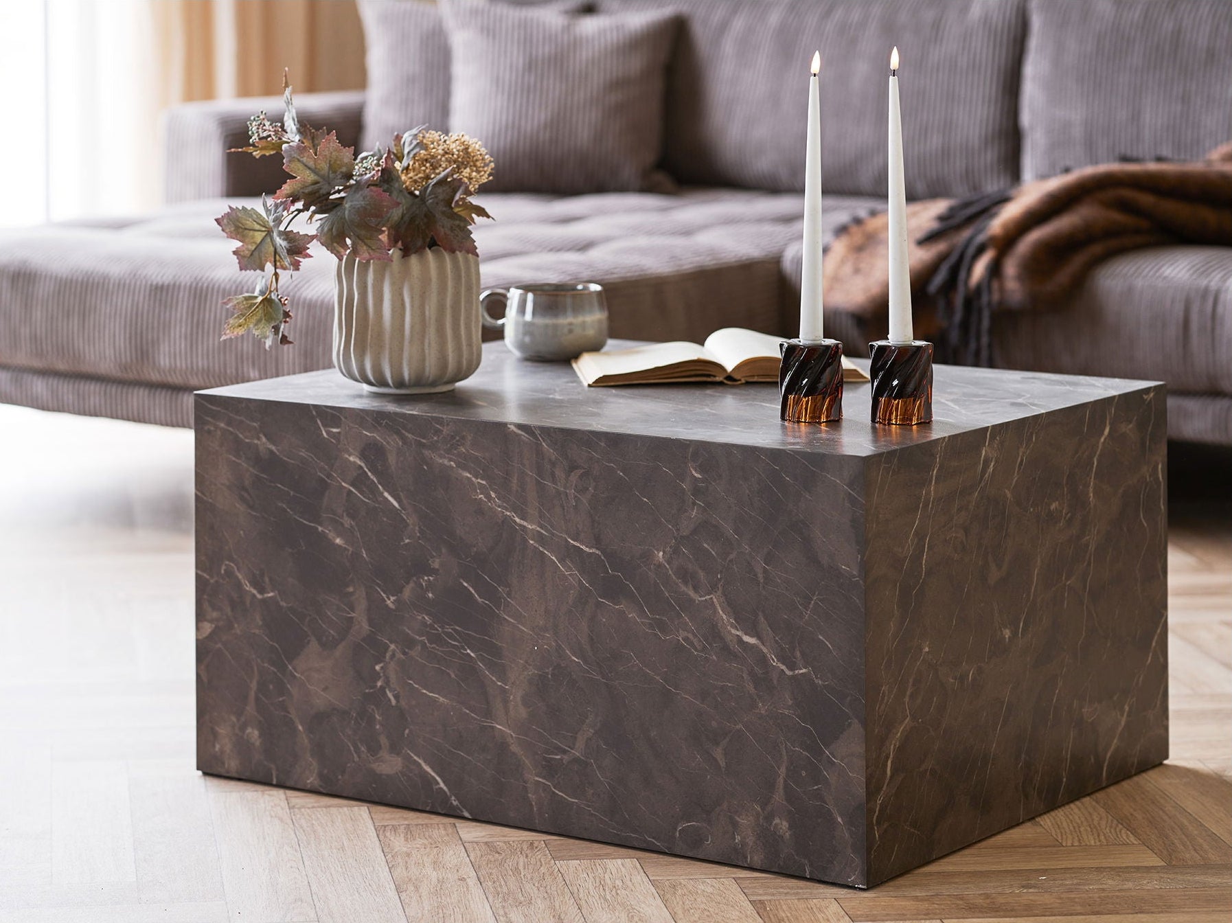 Marble coffee table with decorative items in a living room setting